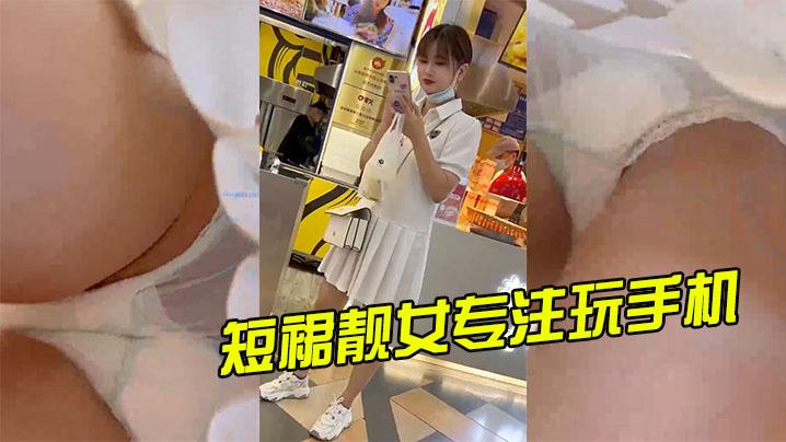短裙靓女专注玩手机谈绿色透明骚内超清抄底