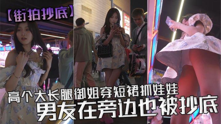 街拍抄底高个大长腿御姐穿短裙抓娃娃男友在旁边也被抄底白色透明内内从前面抄底能看见y毛